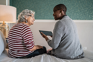 younger woman showing older woman how to work an ipad